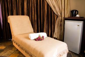 Una habitación con una cama con flores. en Zoete Rust Boutique Hotel, en Lephalale