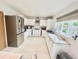 a kitchen with white cabinets and a stainless steel refrigerator at Paradise on earth in Garthamlock