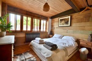 a bedroom with a bed in a room with wooden walls at The Old Forge in Dersingham