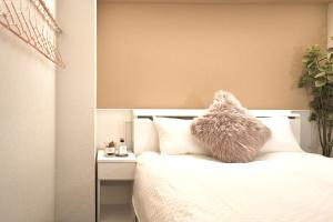 Un dormitorio con una cama blanca con un osito de peluche. en 超级奢华 近秋叶原东京站Kaoa奢华套房带厨房 超豪华戴森&POLA顶级配置 4分钟到东京站 3分钟到地铁, en Tokio