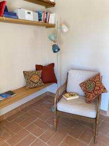 a room with a chair and a shelf with books at il peperino in Castel del Piano