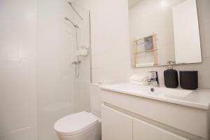 a white bathroom with a toilet and a shower at Comfortable getaway in Medieval Castro Marim in Castro Marim