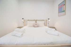 um quarto com uma grande cama branca com almofadas brancas em Comfortable getaway in Medieval Castro Marim em Castro Marim