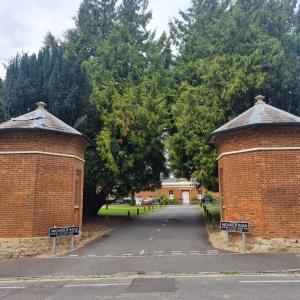 two brick walls with street signs in a driveway at Spacious two bedroom apartment with one parking space in Thame