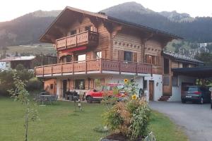 a wooden house with a car parked in front of it at Chalet d'Ayral avec jardin privatif in Leysin
