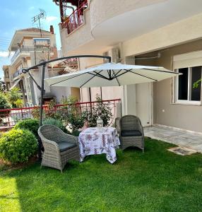 - une table et des chaises sous un parasol sur une cour dans l'établissement Smile studio, à Dráma