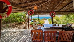 a table and chairs on a patio with a view of the ocean at Stunning Sea View Villa w Garden 5 min to Beach in Gumusluk