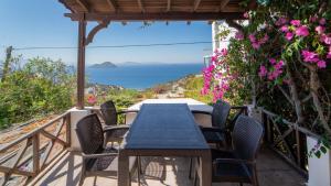 a table and chairs on a balcony with a view of the ocean at Stunning Sea View Villa w Garden 5 min to Beach in Gumusluk