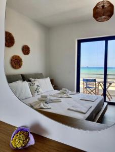 una camera con un grande letto e vista sull'oceano di Kythera Beach Apartments a Diakofti