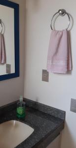 uma casa de banho com um lavatório e um espelho em Apto dois quartos pertinho da praia em Florianópolis