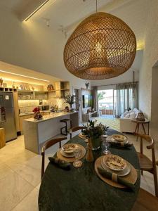 comedor y cocina con mesa y sillas en Villa PF Village - Praia do Lord, en Praia do Forte