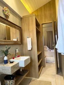 ein Bad mit einem Waschbecken und einem Spiegel in der Unterkunft Villa PF Village - Praia do Lord in Praia do Forte