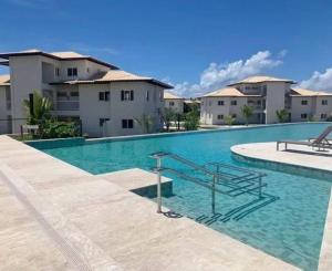 a large swimming pool in front of some buildings at Villa PF Village - Praia do Lord in Praia do Forte +13 photos