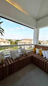 - une terrasse couverte avec des oreillers blancs installés sur un balcon dans l'établissement Villa PF Village - Praia do Lord, à Praia do Forte