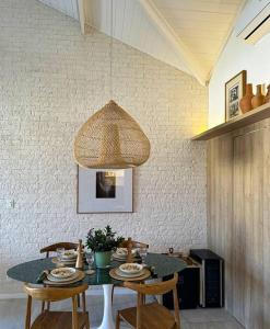 a dining room table with chairs and a pendant light at Villa PF Village - Praia do Lord in Praia do Forte