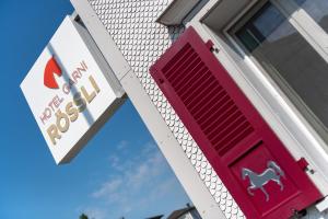 una puerta roja con un letrero de caballo en un lateral de un edificio en Hotel Garni Rössli, en St. Gallen