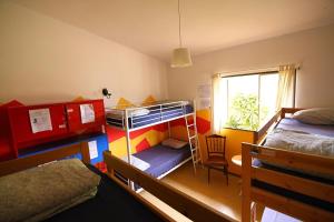 a room with two bunk beds and a window at Lagarto Hostel Tenerife in Valle de Guerra