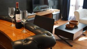 a table with two wine glasses and a leather couch at La Bohemia Casco Antiguo 2 in Denia