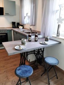 uma cozinha com uma mesa com dois bancos e duas garrafas em Ferienhaus Bayerlipp em Scheßlitz