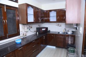 una cocina con armarios de madera y fregadero en Divine India Service Apartment 3Bhk,B57 Sarita Vihar,Apollo en Nueva Delhi