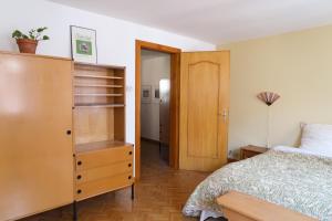 - une chambre avec un lit et une armoire en bois dans l'établissement Chez Mamama, gîte cosy sur la route des vins, à Dambach-la-Ville