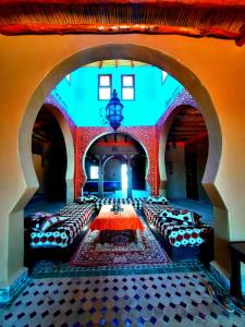 a room with couches and a table in a building at Riad family in Merzouga