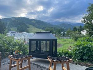 a lantern sitting between two chairs in a garden at Serenity Chalet, walk to the lifts Happoone Ski Resort in Hakuba
