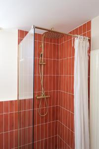 La salle de bains est pourvue d'une douche avec un rideau de douche blanc. dans l'établissement Chez Mamama, gîte cosy sur la route des vins, à Dambach-la-Ville