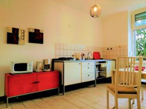 une cuisine avec un four micro-ondes sur une armoire rouge dans l'établissement feelathome, à Essen