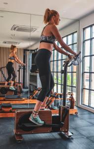 a woman standing on a treadmill in a gym at LalaGalu - Beachfront EcoCabins in Diani Beach