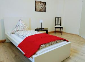 - une chambre avec un lit et une couverture rouge dans l'établissement feelathome, à Essen