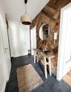 a hallway with a wooden wall with a table and a mirror at Bergzeit by Alpenidyll Apartments in Aich