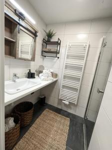 a bathroom with a sink and a mirror at Bergzeit by Alpenidyll Apartments in Aich