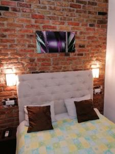 a bed in a room with a brick wall at Apartmani Milica in Banja Luka