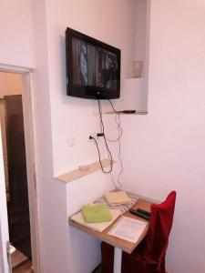 Zimmer mit einem Schreibtisch und einem TV an der Wand in der Unterkunft Apartmani Milica in Banja Luka