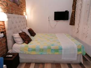 ein Schlafzimmer mit einem Bett und einem TV an der Wand in der Unterkunft Apartmani Milica in Banja Luka