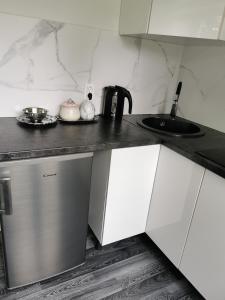 a kitchen with white cabinets and a sink at Jaama Apartement in Valga