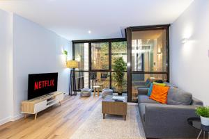 a living room with a couch and a tv at Stay Like Home in Melbourne