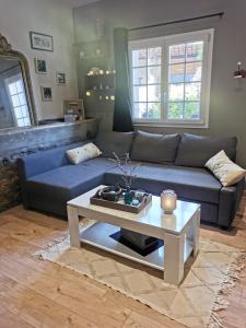 ein Wohnzimmer mit einem blauen Sofa und einem Couchtisch in der Unterkunft gîte Cosy Green 2 in Chevincourt