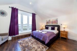 a bedroom with a bed and a large window at Central 4BDR home wgarden & parking in London