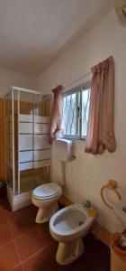 a bathroom with a toilet and a sink and a window at Trilogy in Valenza