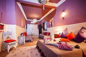 a bedroom with two beds in a room with purple walls at Riad Dar Nadwa in Marrakesh
