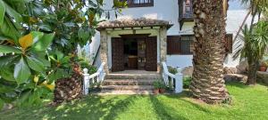 ein Haus mit einem Tor und einer Veranda mit einem Baum in der Unterkunft Casa del Pintor Antonio Mesa in Mombeltrán