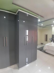 a bedroom with gray sliding doors and a bed at LINGE'S LODGE EXTENSION in Lusikisiki