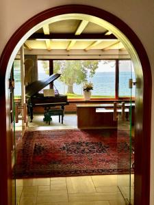 una porta aperta per una stanza con pianoforte e pianoforte a coda di Villa Noho a Nonnenhorn