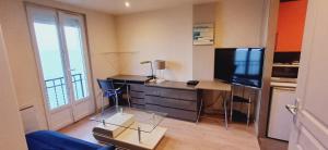 sala de estar con escritorio, TV y mesa en Bellerive, pieds dans l'eau lac & montagnes, en Publier