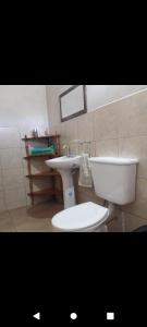 a bathroom with a white toilet and a sink at Cabaña Abra del Monte Monohambiente in Cachí