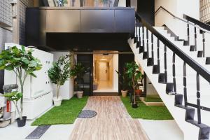 a hallway of a house with plants and stairs at 都心罕见东京奢华设计师Kcob带榻榻米 戴森&POLA顶级配置4分钟到东京站 20分钟到迪士尼 最大3人 in Tokyo