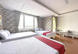 sypialnia z 2 łóżkami i ceglaną ścianą w obiekcie OYO 1196 Le Vu Hotel w mieście Da Lat