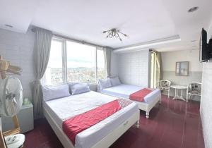 sypialnia z 2 łóżkami i oknem w obiekcie OYO 1196 Le Vu Hotel w mieście Da Lat